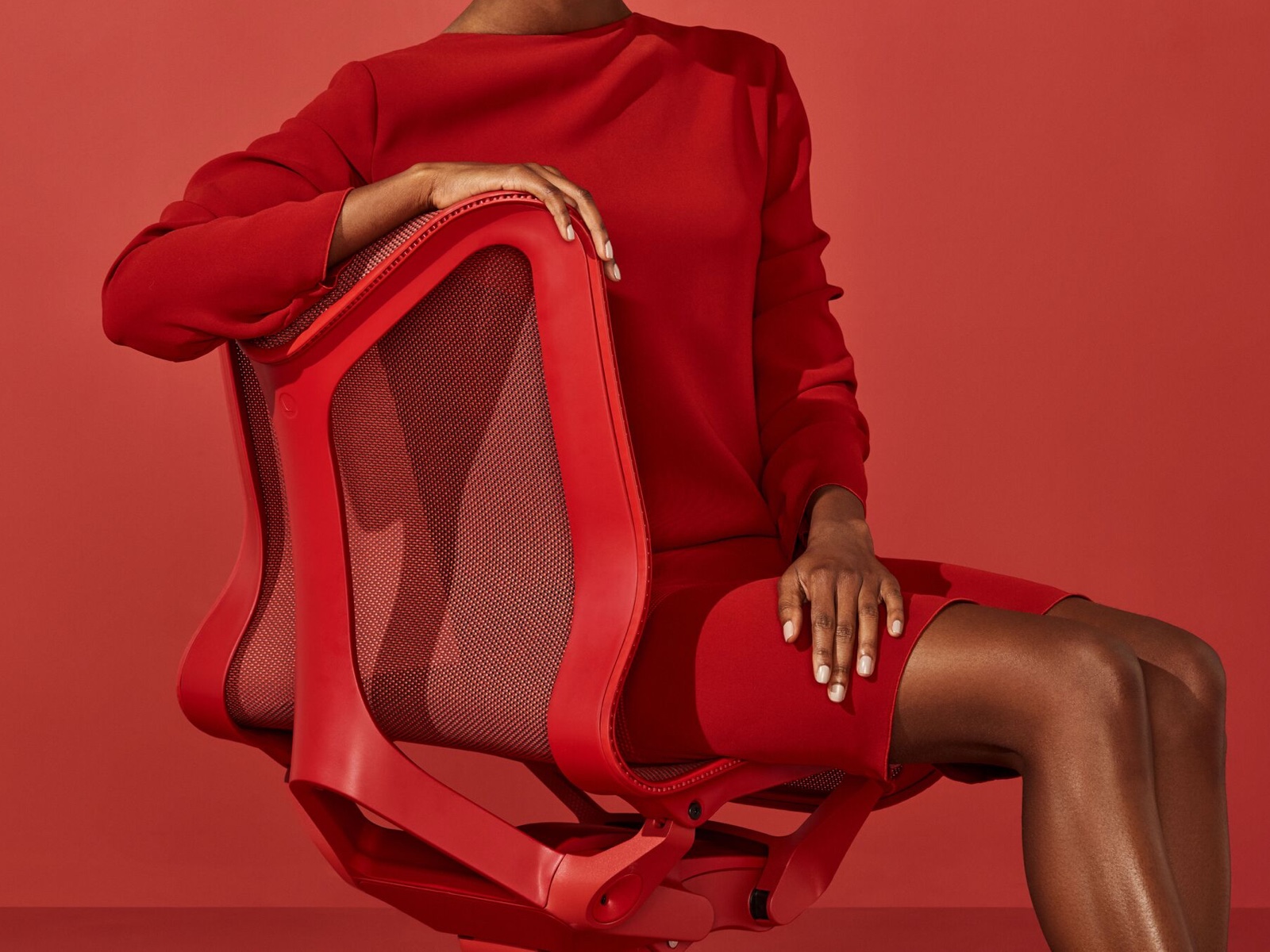 穿红裙子的女士坐在Canyon红色的低背Cosm椅子上。
